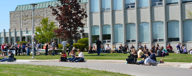 Students eating pizza outside the Faculty of Education building