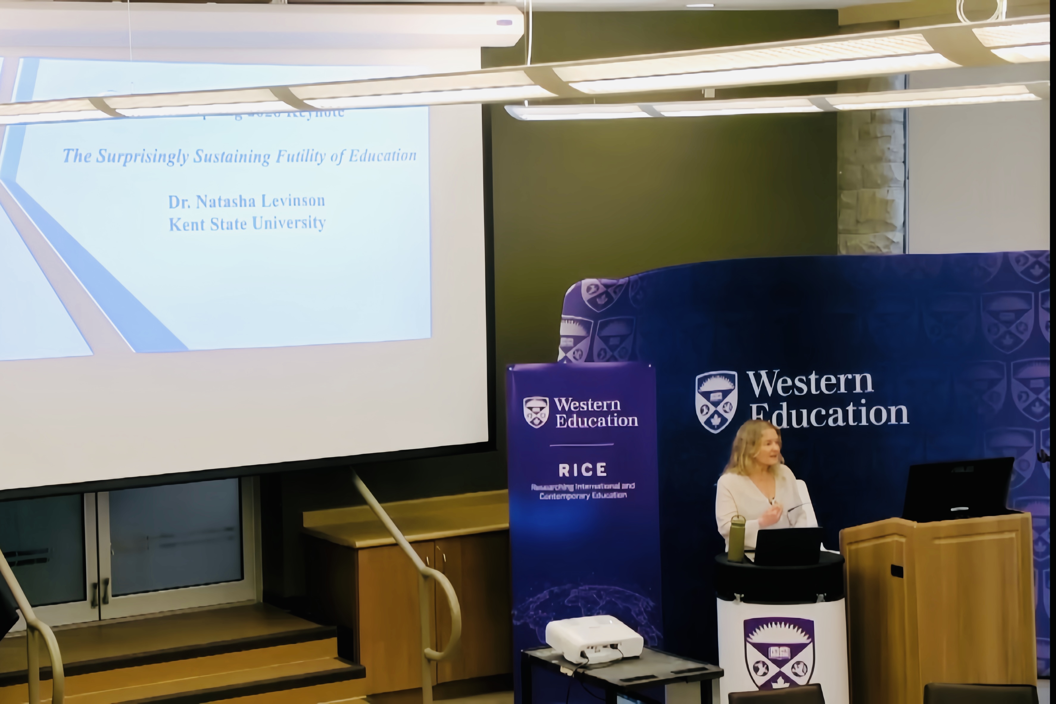 Natasha Levinson stands at a podium giving a presentation