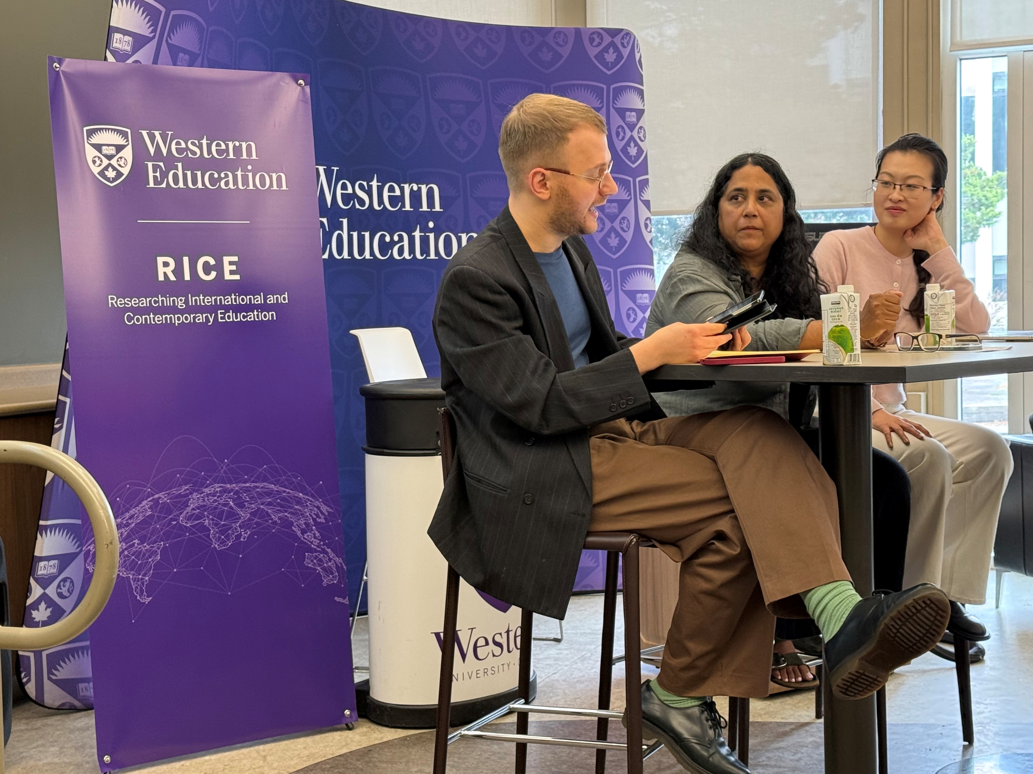 Three panelists speak at a table during the symposium